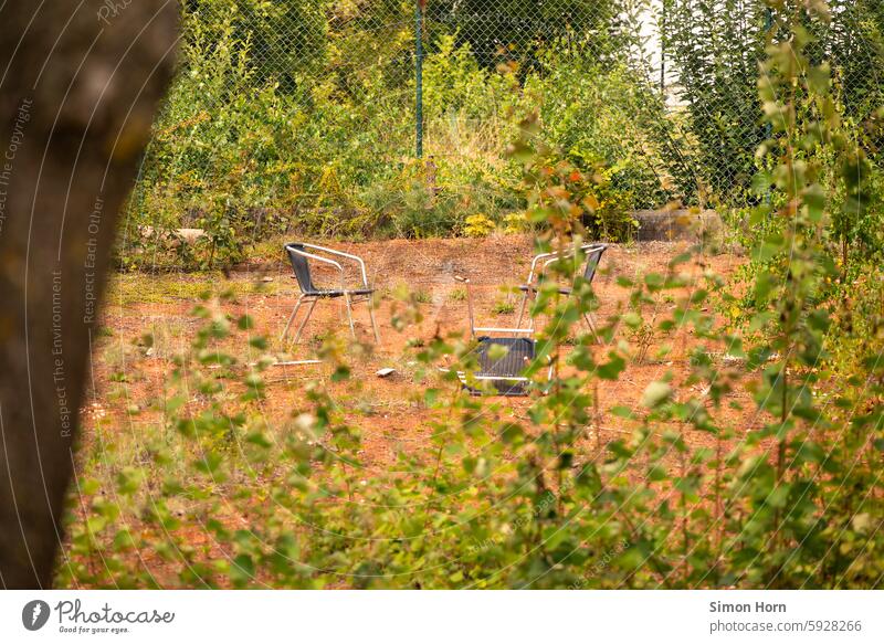 overgrown tennis court with three chairs standing and lying on it unused Fallow land Meeting point Tennis court change Allegory Change Still Life Derelict