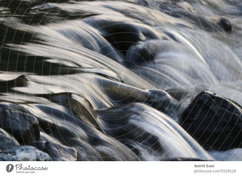 Long exposure of a rushing brook in the evening light Water Brook River Flow Hissing fluid flowing water Near Close-up Evening Waves wave Fresh Nature Outdoors