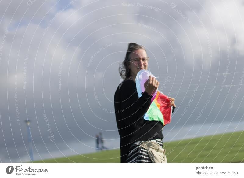 a woman holds a kite in strong winds steering dragon kites rise Wind coast windy cloudy Leisure and hobbies Air Playing Sky