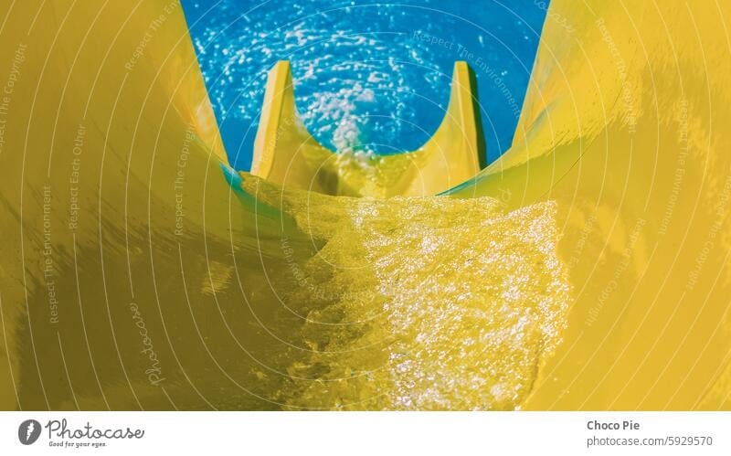 water flowing on a bright yellow hill on the background of the black pool blue closeup color day detailed rest ride slide slide pool stream summer sunny swim