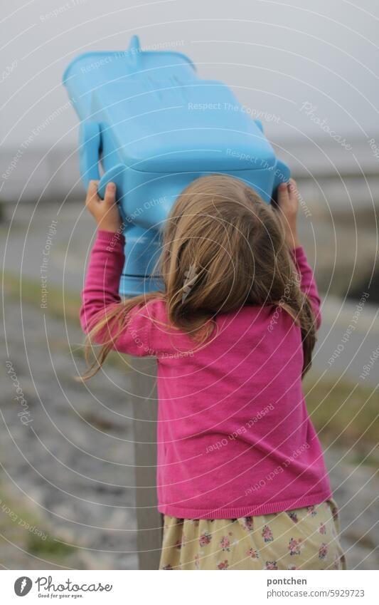 a child looks through a coin telescope at the north sea at low tide. Child Girl colour contrast pink Blue Low tide North Sea Curiosity coast Vacation & Travel