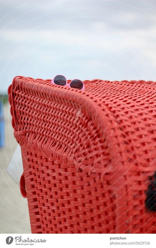 lost and found. found object. a pair of pink sunglasses lying on a red beach chair Discovery Sunglasses colour contrast Beach chair Red vacation Doomed loss