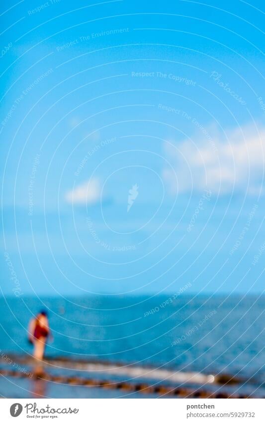 woman in red swimsuit walks by the sea. blurred hazy blurriness Anonymous Joy vacation Ocean untroubled Exterior shot Adults To go for a walk Relaxation