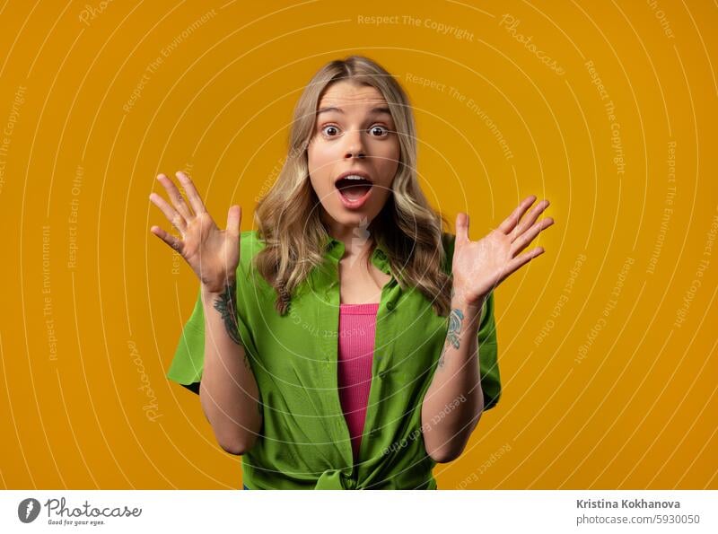 Amazed woman, she expresses WOW. Impressed lady on yellow background. Great news excited female scream caucasian isolated surprise wow amazed funny shocked girl