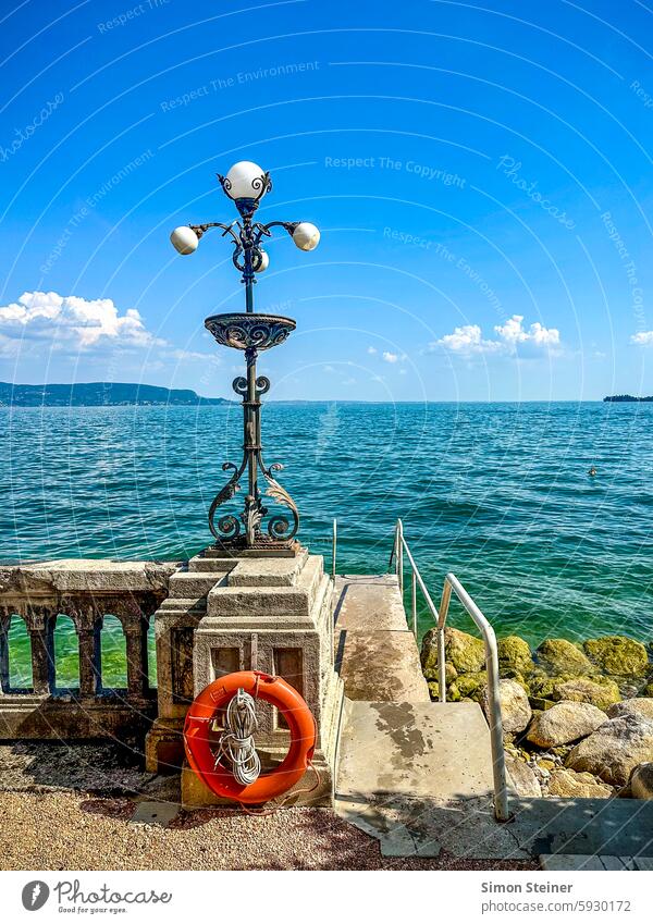 Lake Gardersee promenade in summer Lake Garda Summer bank Blue sky Sky