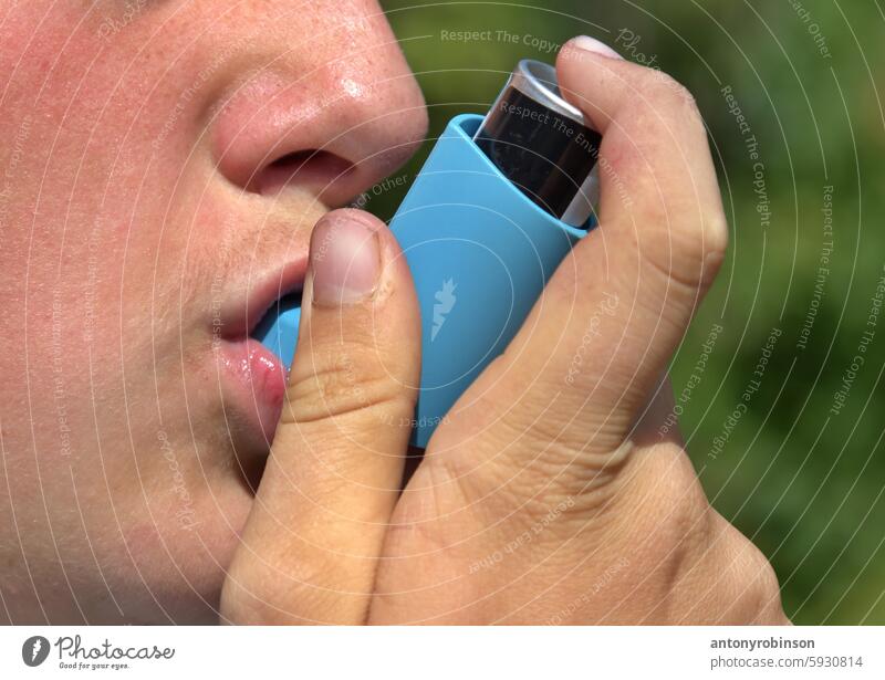 Close up of person using an inhaler breathing medicine horizontal outdoors one person photography recovery asthmatic allergy care holding blue