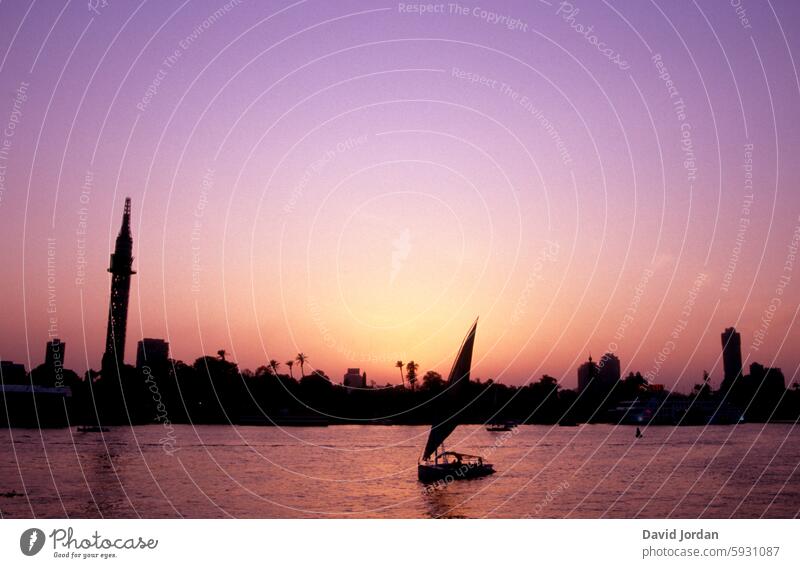 Silhouette of an Egyptian city with sailboat in the foreground and pastel pink-purple sky, sunset mood Sunset Skyline Skyline silhouette Sailboat