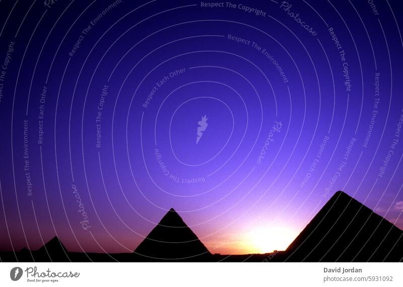 three pyramids in front of a purple sunset Sunset Pyramid Egypt Landmark Cairo Giza Landscape Africa Sky Archeology Sand Historic Tourism