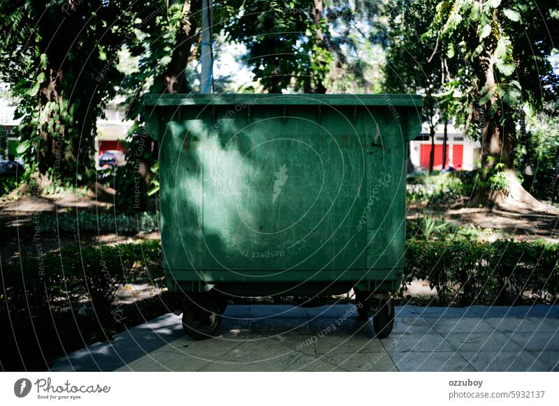 sunlight and shadow of leaves in green bin garbage container environment recycling plastic street dirty pollution can city industrial garbage bin trash