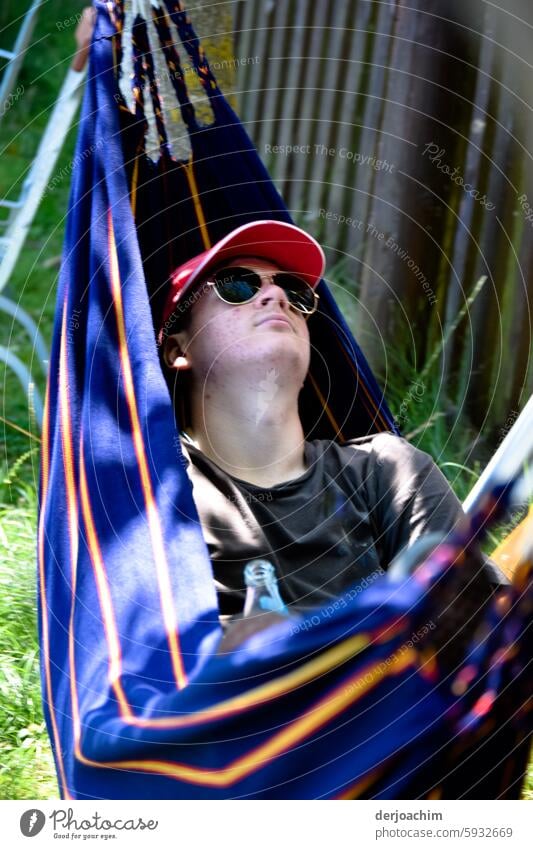 After this Photocase shock, I have to take a nap in the hammock. asleep Sleep Resting portrait Dream Cap Wooden wall Red grassy Sunglasses Day