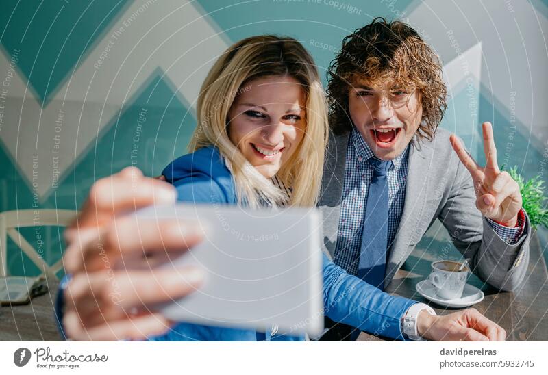 Coworkers taking a selfie celebrating success coworkers business victory win photo smiling smartphone coffee break cafe pause young people cup friends man