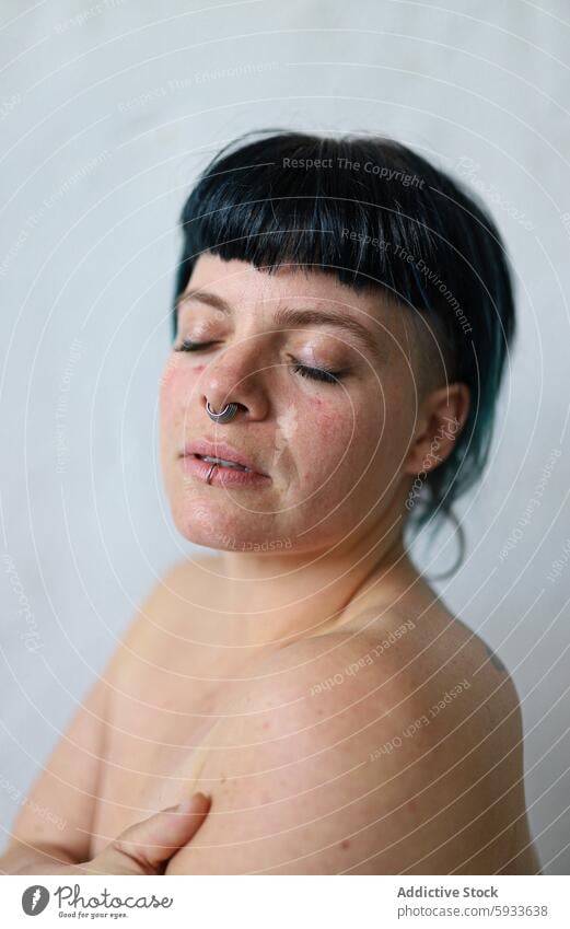 Portrait of a woman with eyes closed and subtle expression portrait close-up serene black hair nose piercing peaceful calm introspective natural skin minimalist