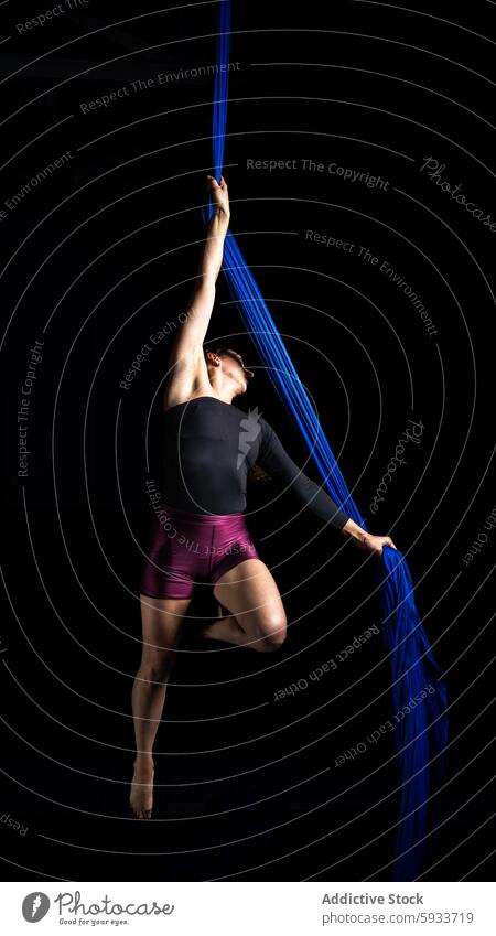 Graceful aerial dance performance by a woman in blue silk flexibility strength grace art fitness acrobat fabric movement artistic body elegant exercise posture