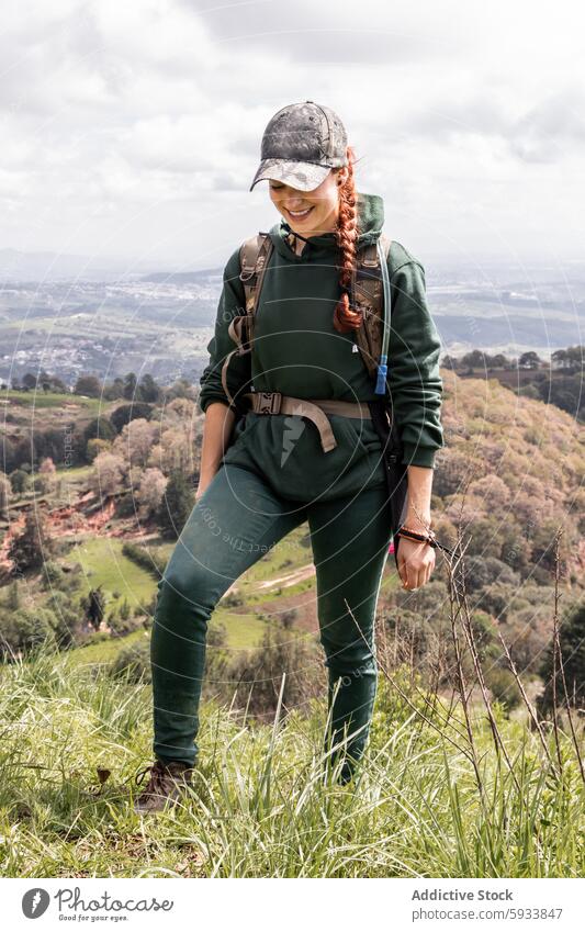 Female hiker enjoying scenic mountain view woman nature landscape outdoor adventure trekking exploring green attire caucasian female backpack looking away grass