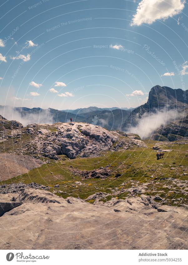 Exploring the majestic Picos de Europa landscape with a distant hiker explorer picos de europa cantabria mountain rock mist serene nature outdoor backpack