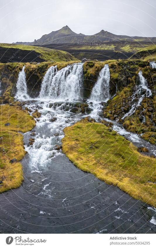 Pristine waterfalls in Iceland's rugged highlands iceland mountain river landscape nature serene cascading flow moss rock terrain green outdoor scenic view