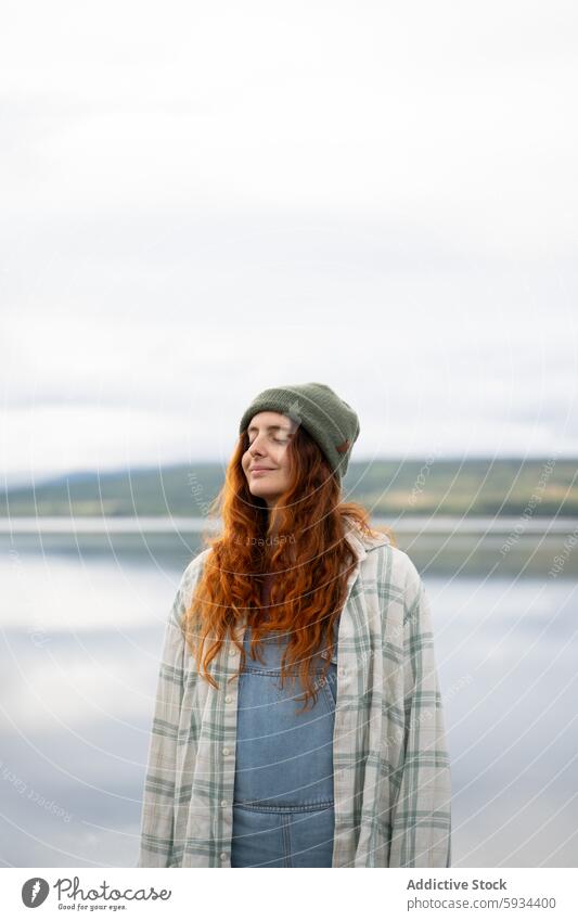 Woman enjoying peaceful moment by lakeside during camping woman nature relaxation tranquility outdoor casual smile gentle serene dress landscape leisure