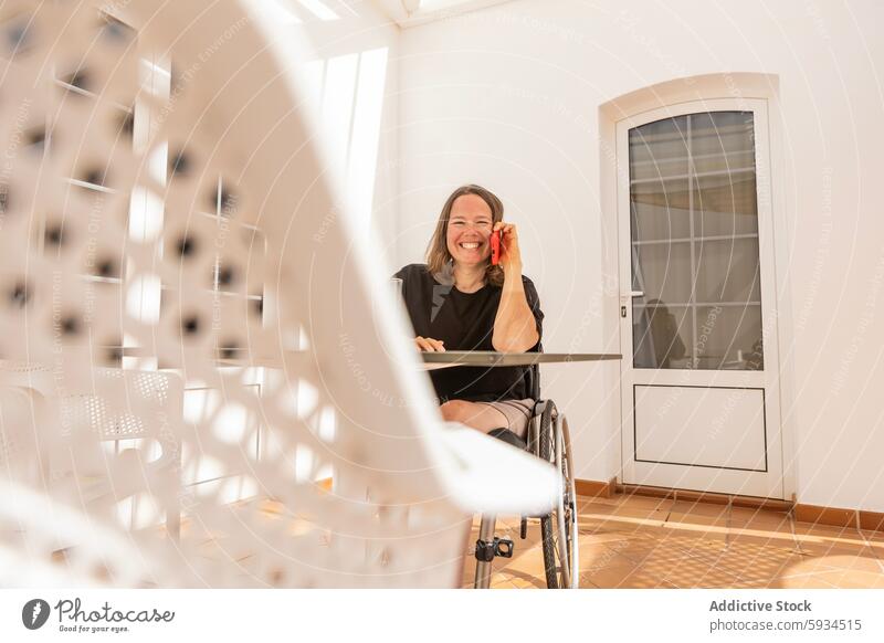 Happy businesswoman in wheelchair working at home phone bright room happy disability accessible inclusion independence engagement joyous client communication