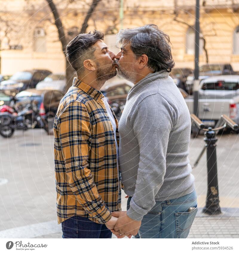 Affectionate gay couple sharing a kiss outdoors affection love commitment street embrace tenderness relationship romantic public diversity inclusivity city day