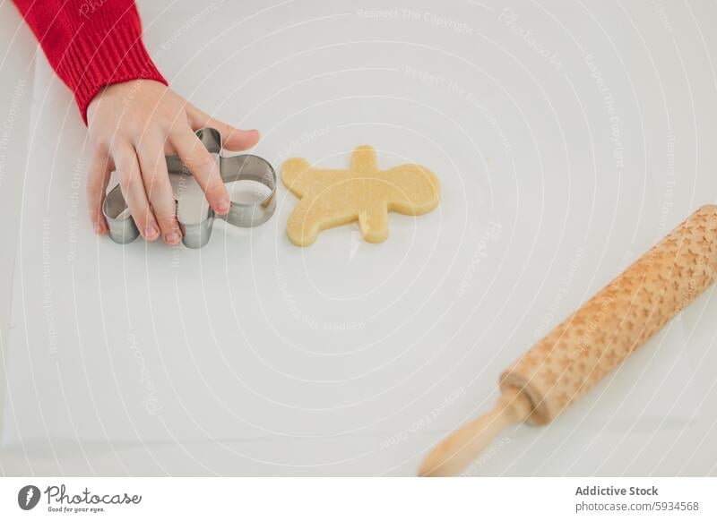 A child baking Christmas cookies in festive attire christmas cutter rolling pin holiday kitchen cooking homemade joy celebration tradition ingredient dough hand