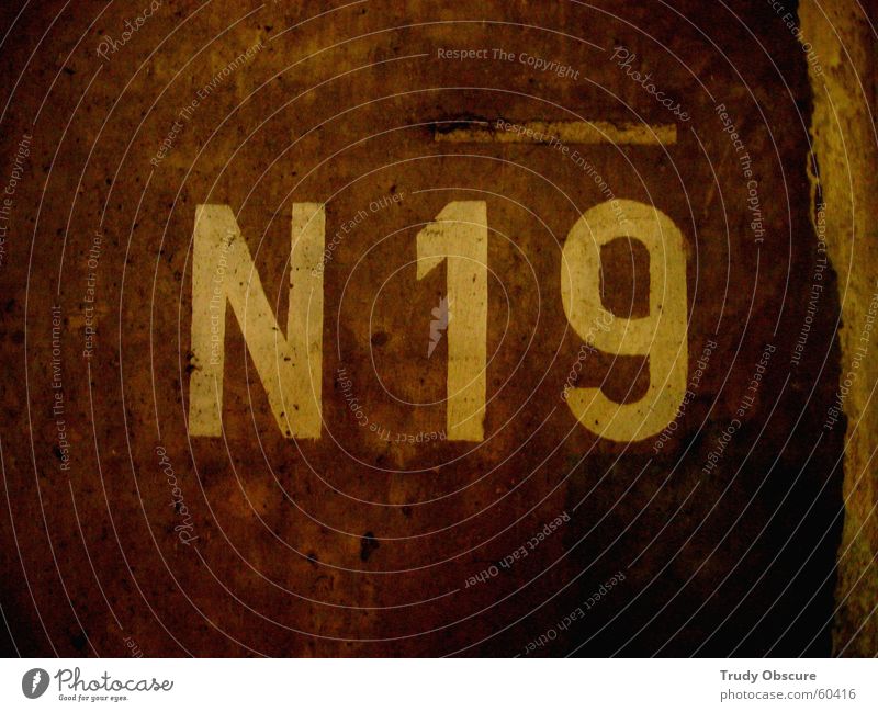 N - nineteen - 19 Background picture Wall (building) Wall (barrier) Surface Concrete Digits and numbers Letters (alphabet) Characters Brown Dark Illogical