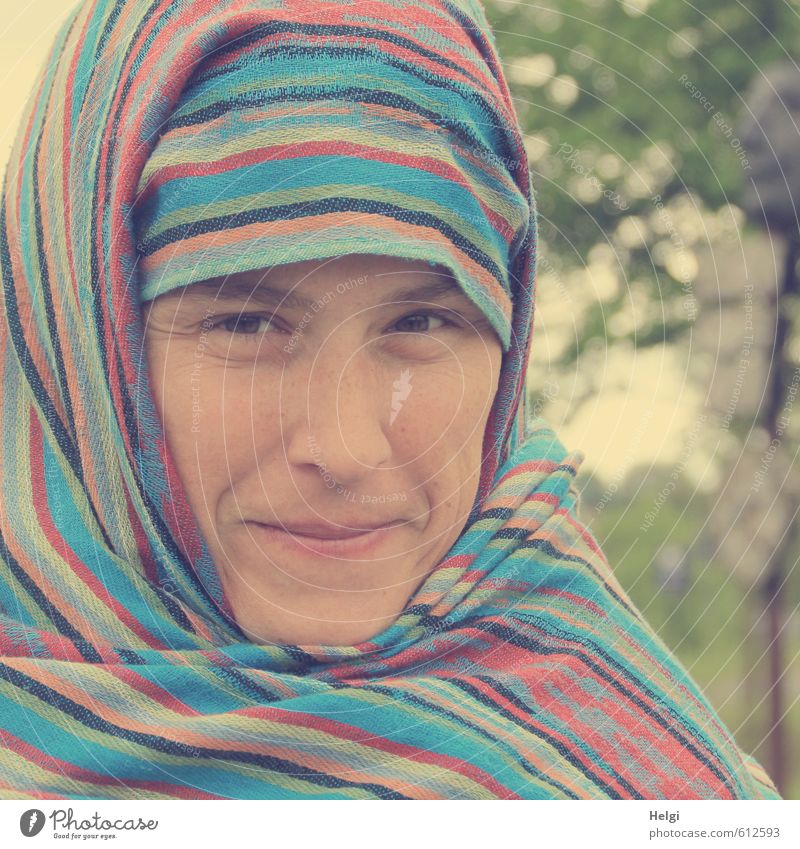 Portrait of a smiling woman who has wrapped her head in a colourful striped scarf Human being Feminine Woman Adults Face 1 30 - 45 years Headscarf Smiling