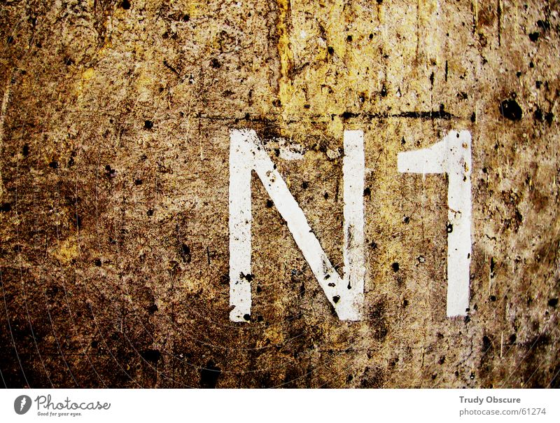 postcard no. 1 Background picture Wall (building) Wall (barrier) Surface Concrete Digits and numbers Letters (alphabet) Characters Brown White Dark back wall