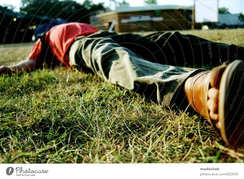 Man lying unconscious or asleep in a meadow during a festival - Alcohol  consumption - a Royalty Free Stock Photo from Photocase