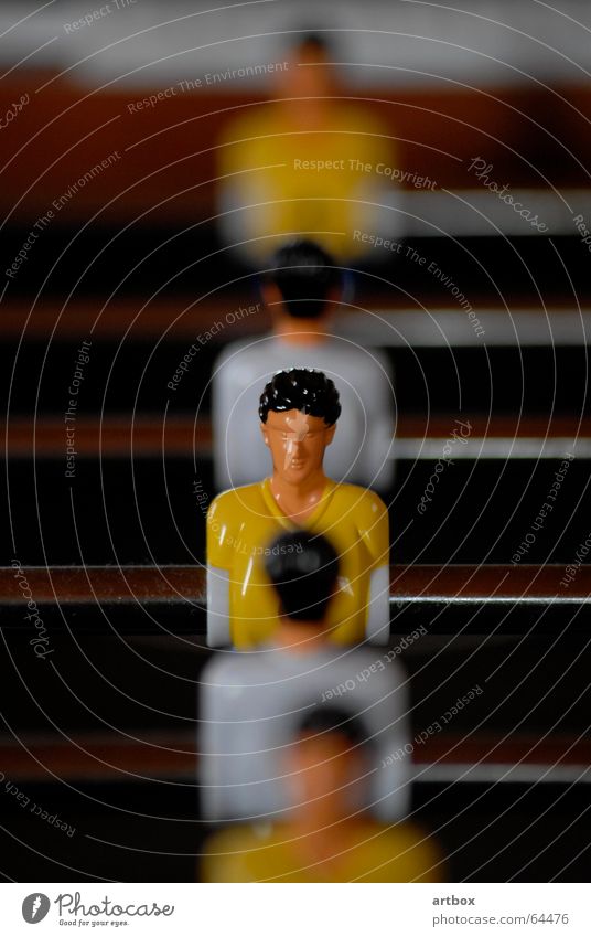 man to man Table soccer Motionless Blur Playing Adversary Jersey Yellow White Piece Rod unmoved Line Row Shallow depth of field Behind one another Opposite