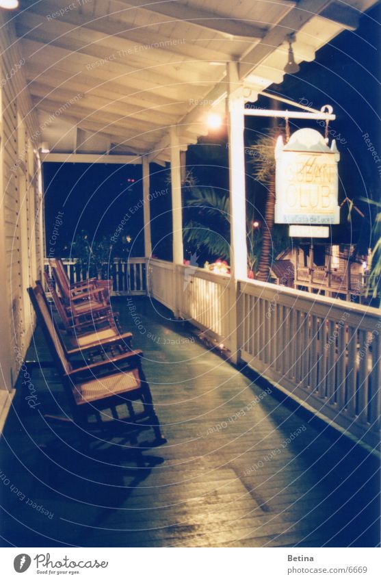 rocking chair Subdued colour Evening Night Artificial light Long exposure Deserted Terrace Serene Patient Calm Key West Florida Rocking chair Exterior shot