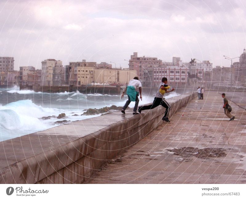 children at malecon Cuba Ruin Ocean Atlantic Ocean Clouds Child Playing Leisure and hobbies Jump Waves Momentum White crest Effervescent Pothole Wall (barrier)