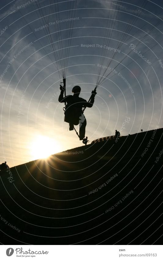 Paragliding pilot on the southern slope of the Wasserkuppe (Rhön) - backlighting Paraglider Flying sports Sunset Sports