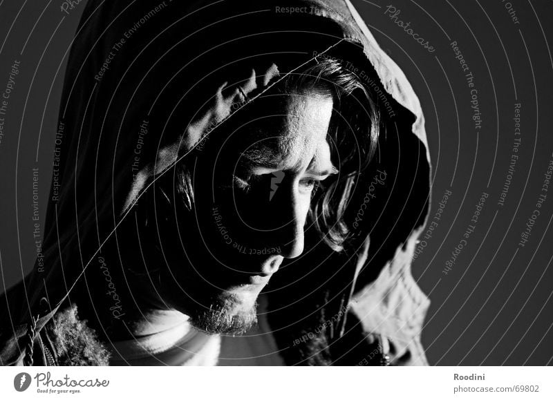 Looking down Man Portrait photograph Dark Hooded (clothing) Objective Thought Think Facial hair Parka Human being Eyes Face Black & white photo Observe