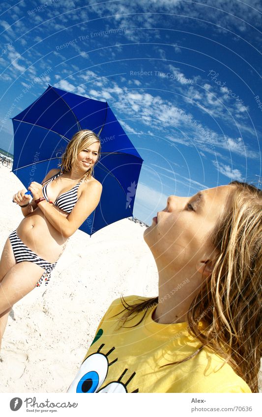 Pretty preteen girl in bikini swimsuit playing with sand in umbrella shadow  during summer tropical vacation Stock Photo