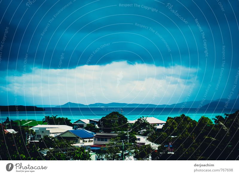 Very dark clouds,almost black,houses and trees in the foreground,other islands in the background Thursday Island-Torres Strait, far north of Queensland, Australia.,Cyclone is approaching,