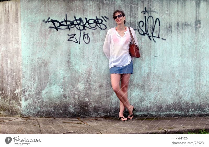 At the wall Mini skirt Blouse Woman Wall (barrier) Sidewalk Dirty Laughter Old Graffiti