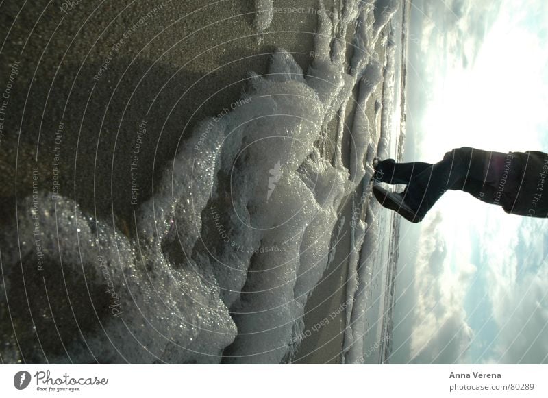 North Sea foam Foam Ocean Sylt Coast Winter Jacket Shoe sole Worm's-eye view Clouds Gray clouds Low tide Brilliant Cold Beach Sand Sun Legs Feet Chucks Jeans