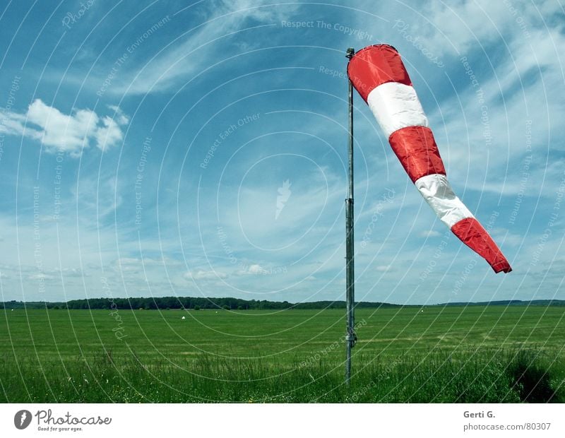 Wind in a bag Windsock Smear Wind direction Red Clouds Sky blue Striped Air Meadow Airfield Grass Flagpole Hang Green Airy Fresh Band of cloud Blue Airspace