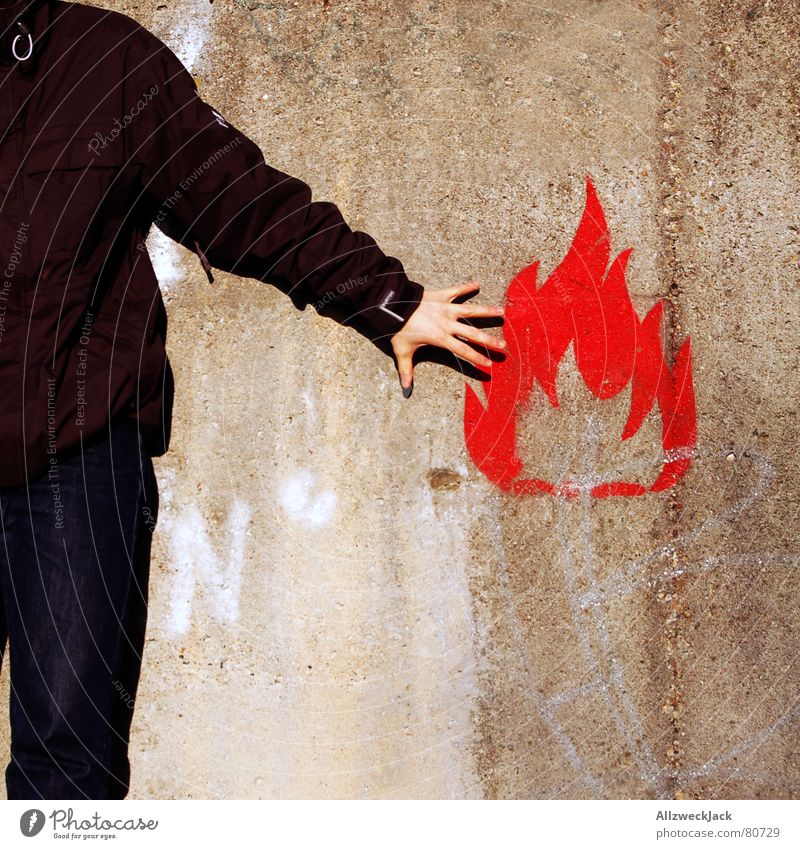 flammable Fire alarm Burn Man Wall (building) Wall (barrier) Symbols and metaphors Ignite Hand Red Young man Kindle Blaze Dangerous Graffiti Mural painting