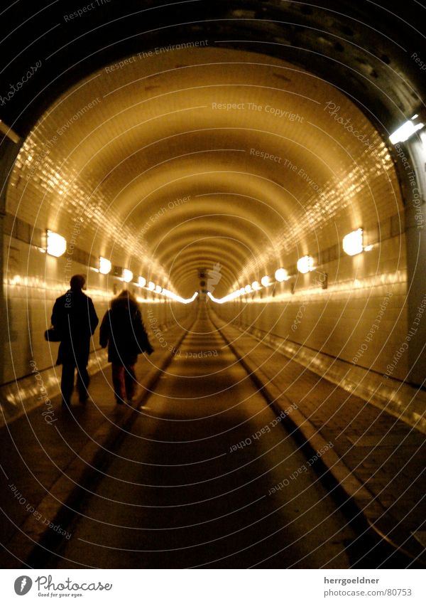 Elbe Tunnel Far-off places Lamp Infinity Traffic lane Pedestrian underpass 2 Yellow Brown Man Woman Oppressive Dark Historic Hamburg Line road toll Couple