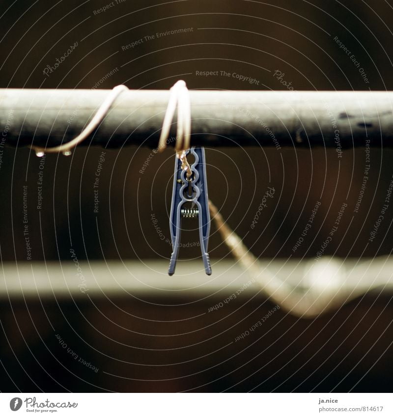 got caught Garden Clothesline Clothes peg Housekeeping Rainwater Metal Plastic To hold on Hang Old Dark Wet Gloomy Blue Gray Sadness Loneliness Environment