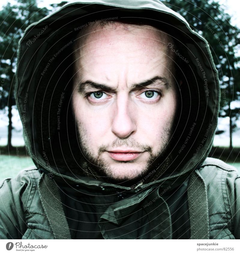portrait Portrait photograph Hooded (clothing) Jacket Green Tree Fear Facial expression Facial hair Face Skin color Concern Facial colour Glade Young man Fix