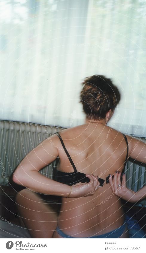 Naked Woman Taking Off Or Putting On Bra Behind The Glass. Stock