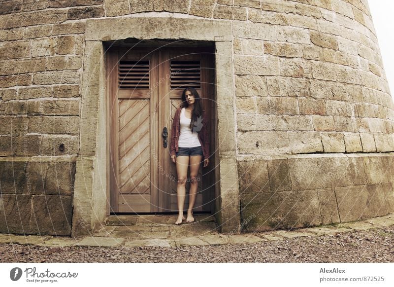 Portrait of a young woman standing in front of the wooden door of a stone tower Young woman Youth (Young adults) Barefoot 18 - 30 years Adults Castle Tower