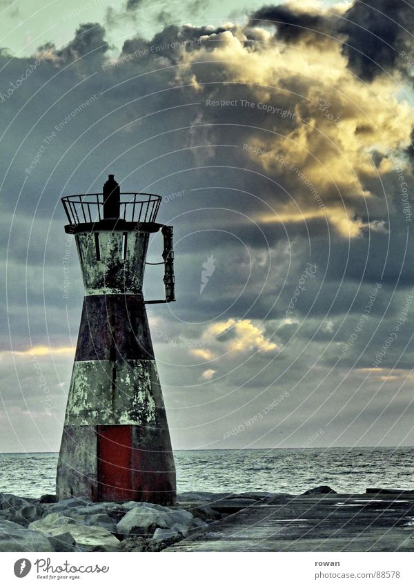 silent guard Lighthouse Red Striped Dirty Rough Ocean End Clouds Dike Jetty Sunset Calm Watercraft Navigation Safety Old Far-off places Watchfulness Indicate
