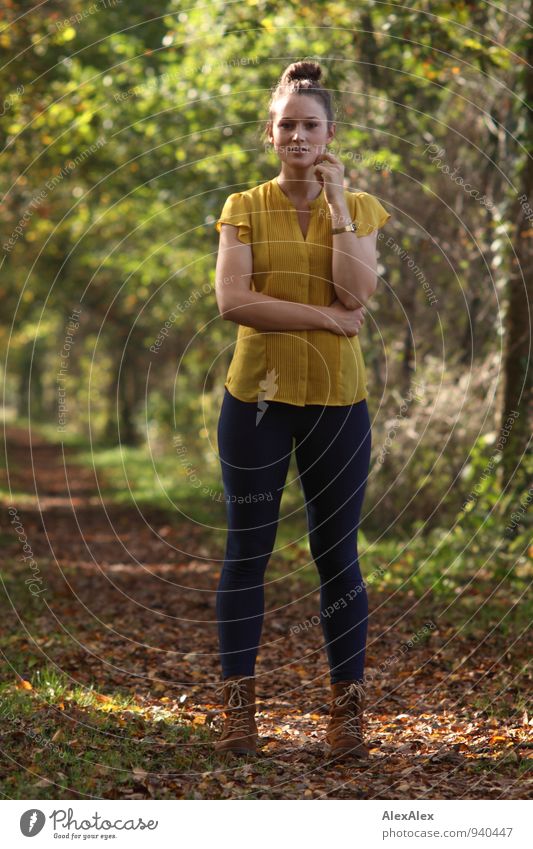 Young woman in yellow top and jeans is standing in front of a tree-lined path Trip Hiking Youth (Young adults) 18 - 30 years Adults Landscape Beautiful weather