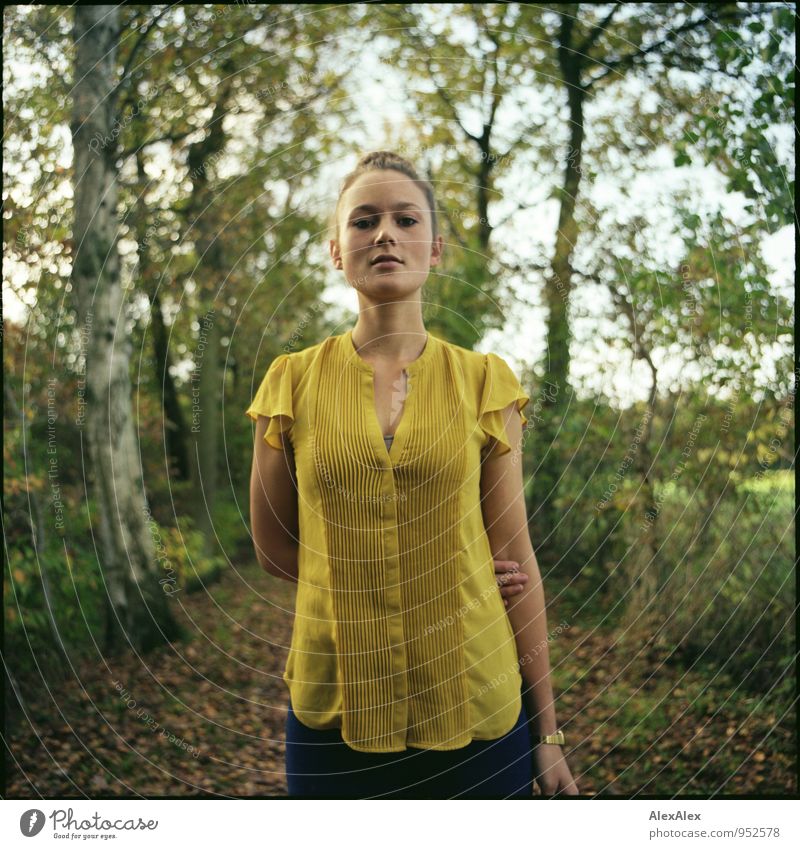 Young woman in yellow top stands in front of a tree-lined path Style Trip Adventure Youth (Young adults) 18 - 30 years Adults Beautiful weather Tree Leaf Field