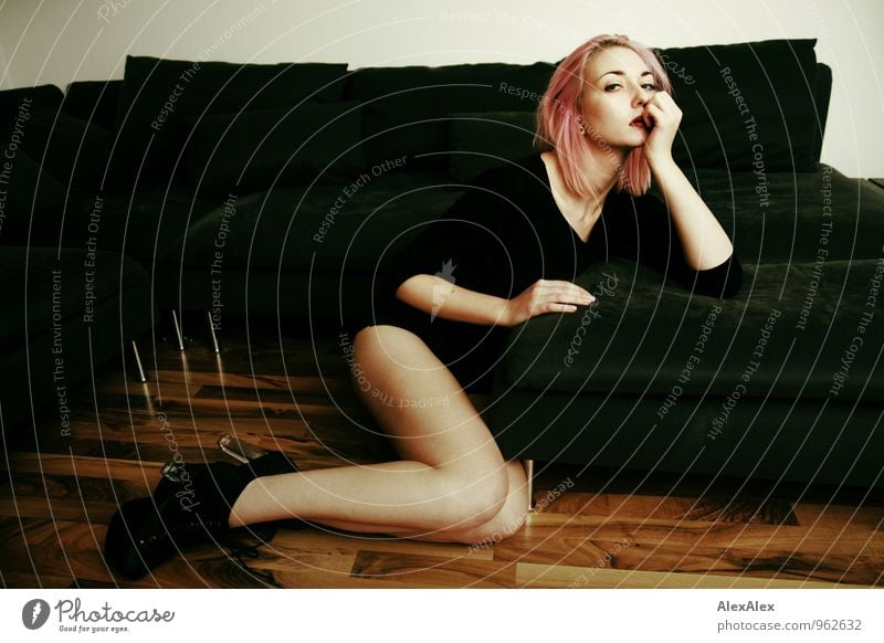 young leggy woman with pink hair sits in front of couch Living or residing Flat (apartment) Sofa Wooden floor Young woman Youth (Young adults) Face Legs