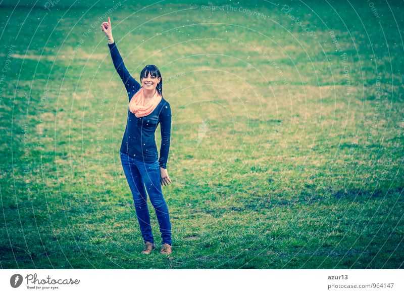 Winter ideas. Beautiful young girl stretching her finger upwards while snowing on a green meadow. pretty Human being Young woman Youth (Young adults) Woman