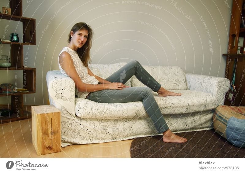 young, tall, leggy woman sits barefoot on a light couch Flat (apartment) Sofa Living room Young woman Youth (Young adults) Legs Barefoot 18 - 30 years Adults